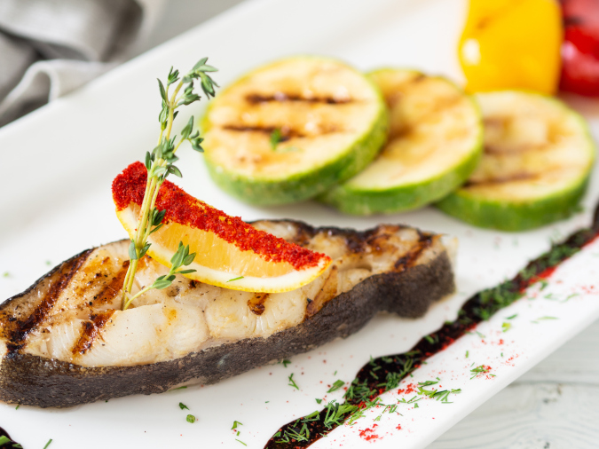 Baked halibut steak with lemon and veggies